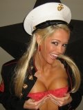 Smiling tanned blonde Foxy Jacky in uniform shows her smoothest pussy and round tits