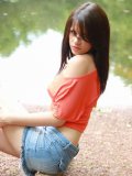 Sweet Ann Angel in blue jean mini skirt and red t-shirt spreads poses on the bank of the river