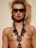The blonde babe Inna F poses in hat, in sexy stockings and in sun glasses